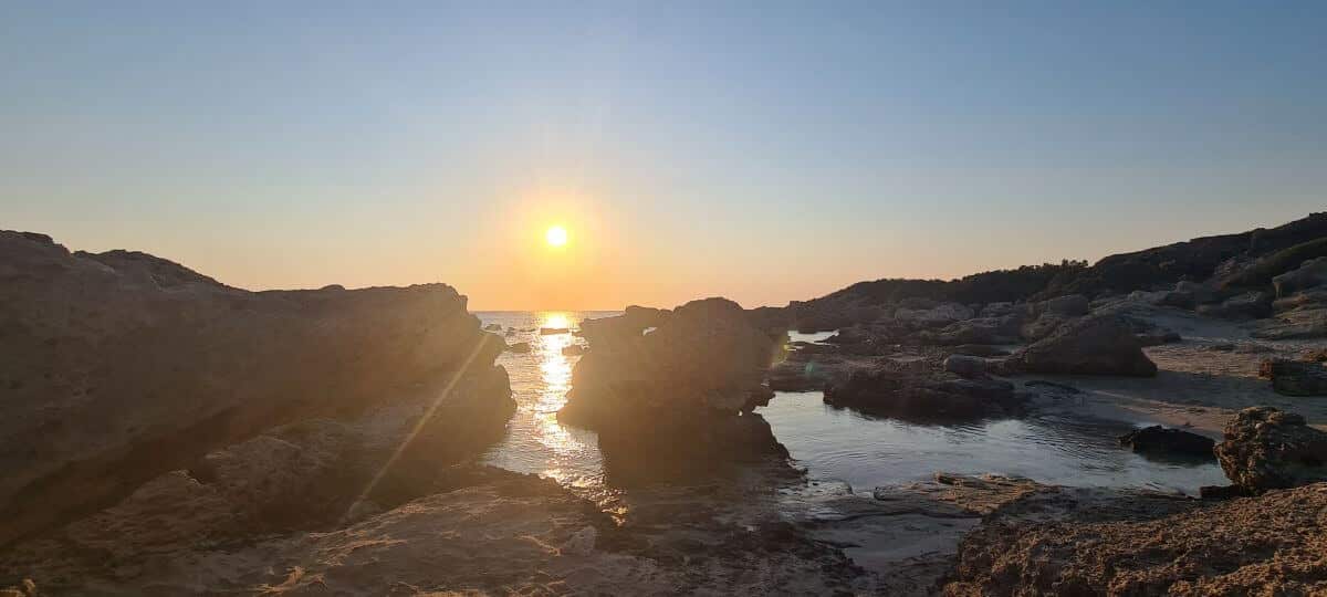El sol se pone entre las rocas de Falassarna El sol se pone entre las rocas de Falassarna
