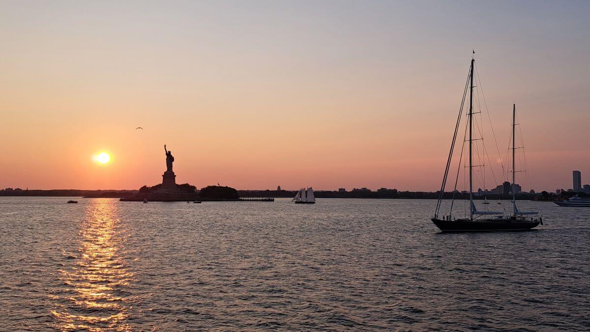 Veleros al atardecer junto a la Estatua de la Libertad Veleros al atardecer junto a la Estatua de la Libertad